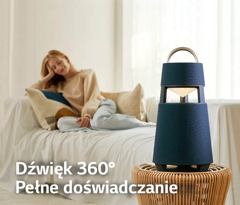 Obraz kobiety siedzącej na sofie i słuchającej muzyki ze stojącego przed nią głośnika XBOOM 360.
