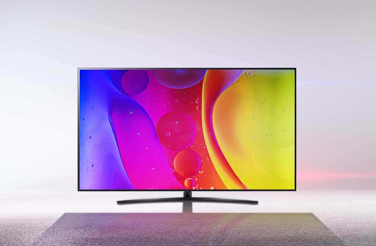 Telewizor w olśniewająco białym pokoju wyświetla jasne, hipnotyzujące kolory na ekranie.