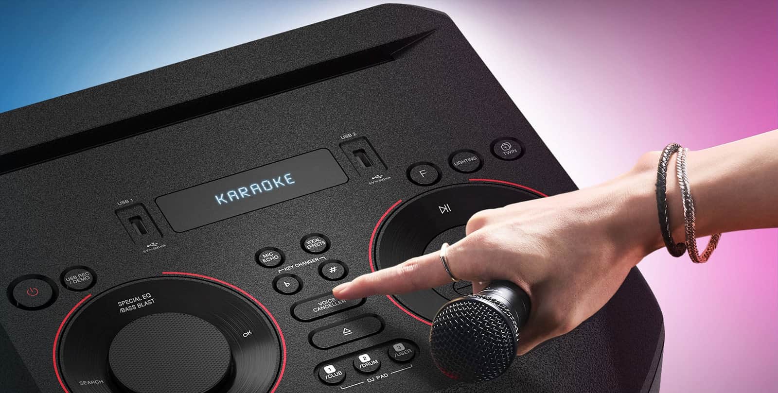Ręka trzymająca mikrofon próbująca nacisnąć przycisk Voice Canceller u góry urządzenia LG XBOOM.