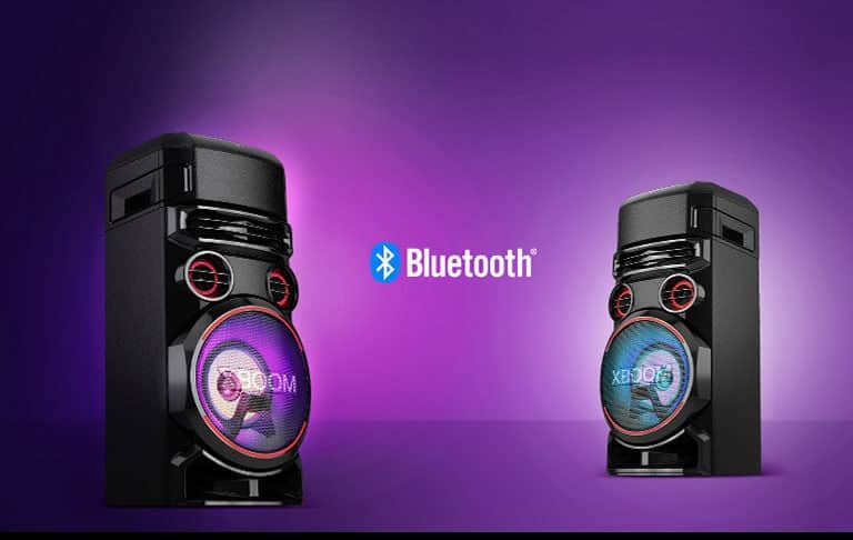 Dwa głośniki LG XBOOM ustawione przodem do siebie pod kątem na fioletowym tle z logo Bluetooth między nimi.