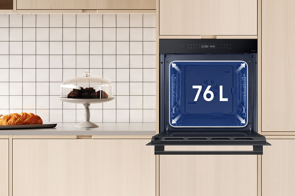 Ilustracja zainstalowanego w kremowej kuchni piekarnika Samsung, który ma sporą pojemność - to aż 76 litrów