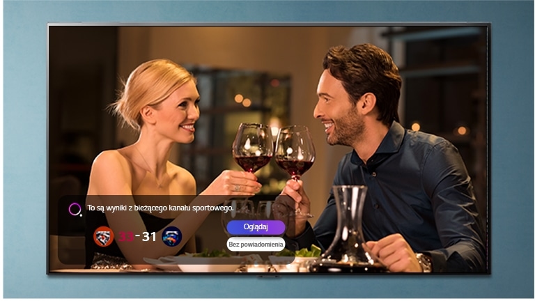 Чоловік і жінка цокають окулярами на екрані телевізора, на якому відображається спортивне сповіщення