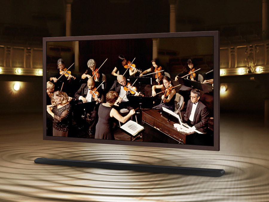 The Frame is showing an orchestra on its screen. The Soundbar is below The Frame with sound ripples coming out of it to show that the sound of the speakers on The Frame and Soundbar are perfectly synced. LS03BBUXXH